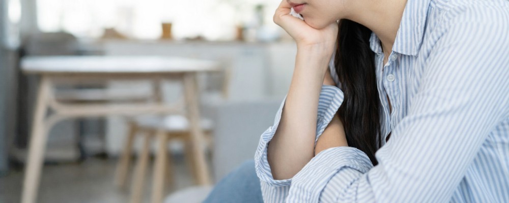 女性が座って悩んでいる画像