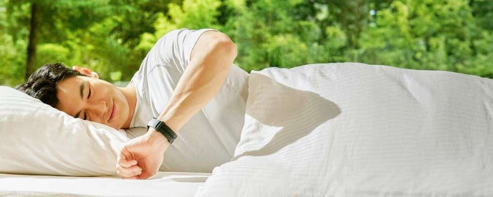 男性が横たわりながらガーミン時計を確認する画像
