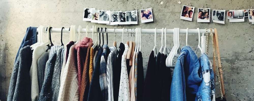 沢山の服がハンガーにかけられてる画像
