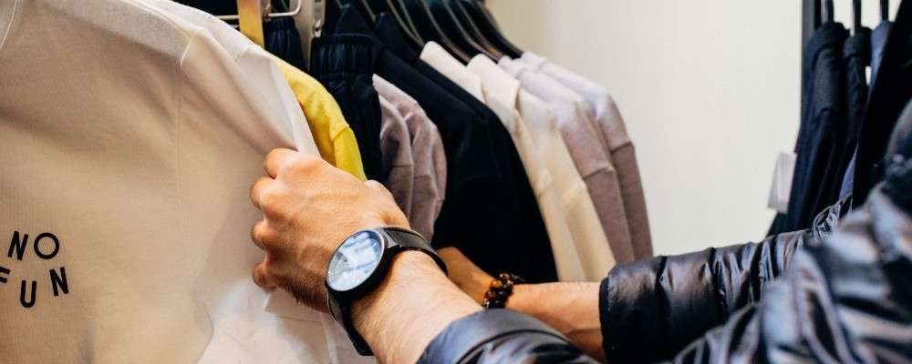 服を選ぶ男性の画像