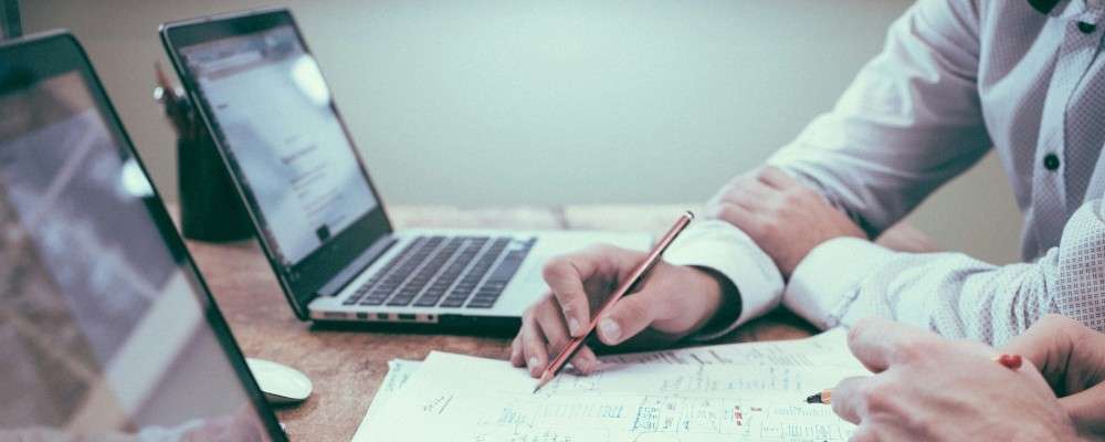 デスクワークで話し合いをする人物画像