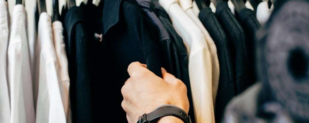 吊るされた黒いシャツを持っている人の画像