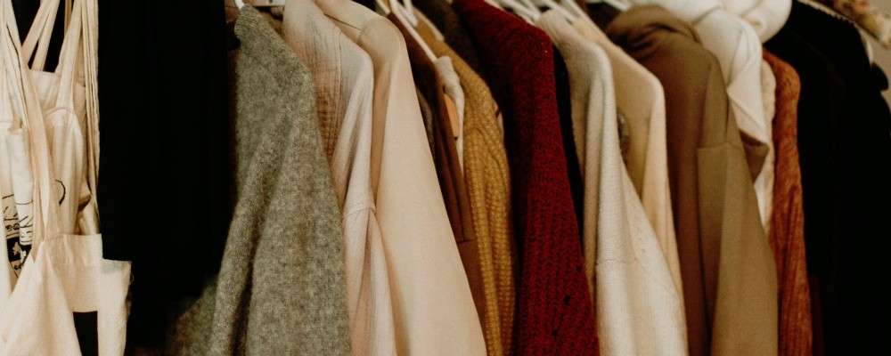 茶色と白のコートがラックに吊るされている