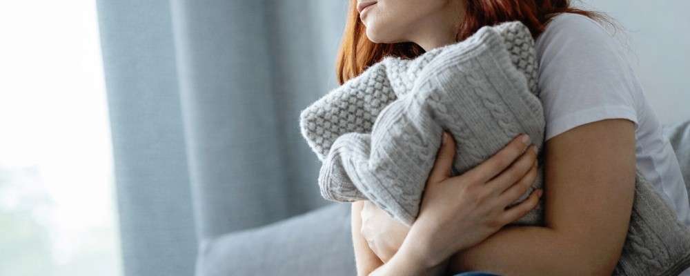 家で服を抱きしめる女性