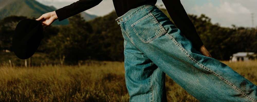 黒の長袖シャツとブルーデニムジーンズを着た女性