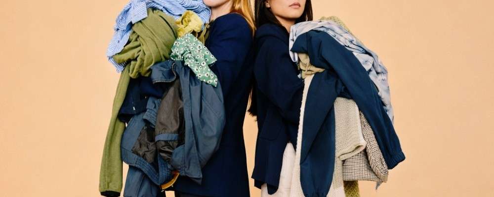 沢山の服をかかえた2人の女性