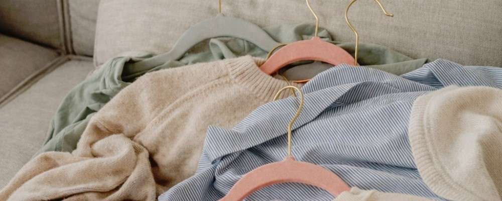 ソファの上に置かれた沢山の衣類
