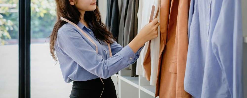 スタジオでデザインに取り組んでいる女性ファッションデザイナーの画像