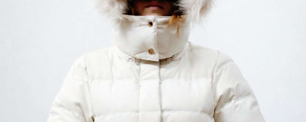 白いフード付きの冬用コートを着た人物の画像